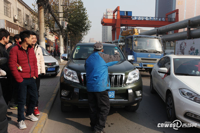 西安一男子馬路上強行攔車給錢才放行