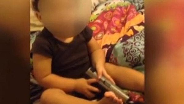 1岁大宝宝手枪塞嘴 美国一对夫妇放任孩子玩枪