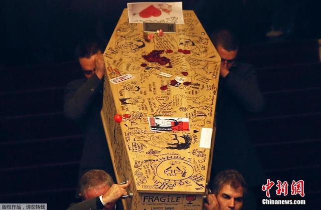 《查理周刊》遇难员工葬礼 同事在棺材上作画
