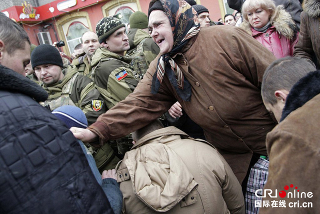 乌克兰政府军战俘被迫在遇袭公交站下跪