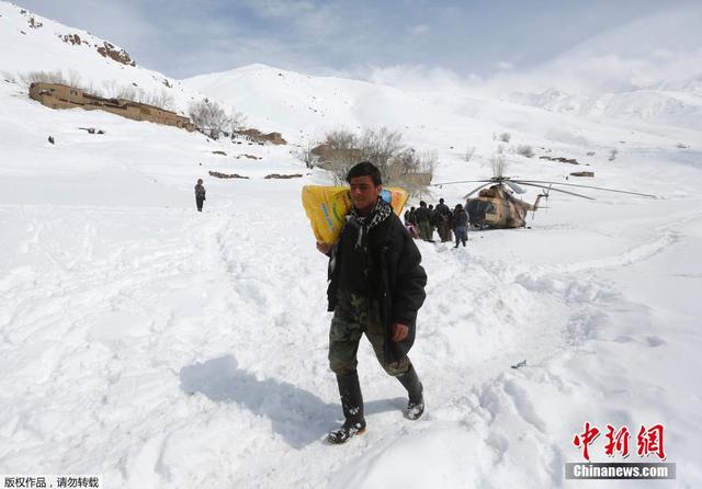 阿富汗雪崩幸存者搬运救援物资 跪雪地祈祷