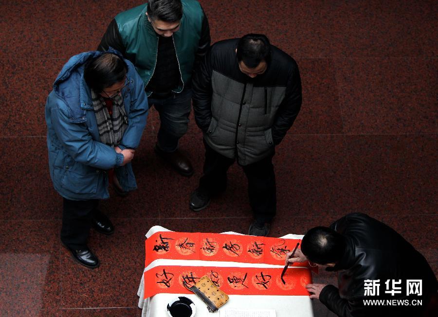 2月15日，来自北京书协的王献坤在新春小庙会上为村民写春联。