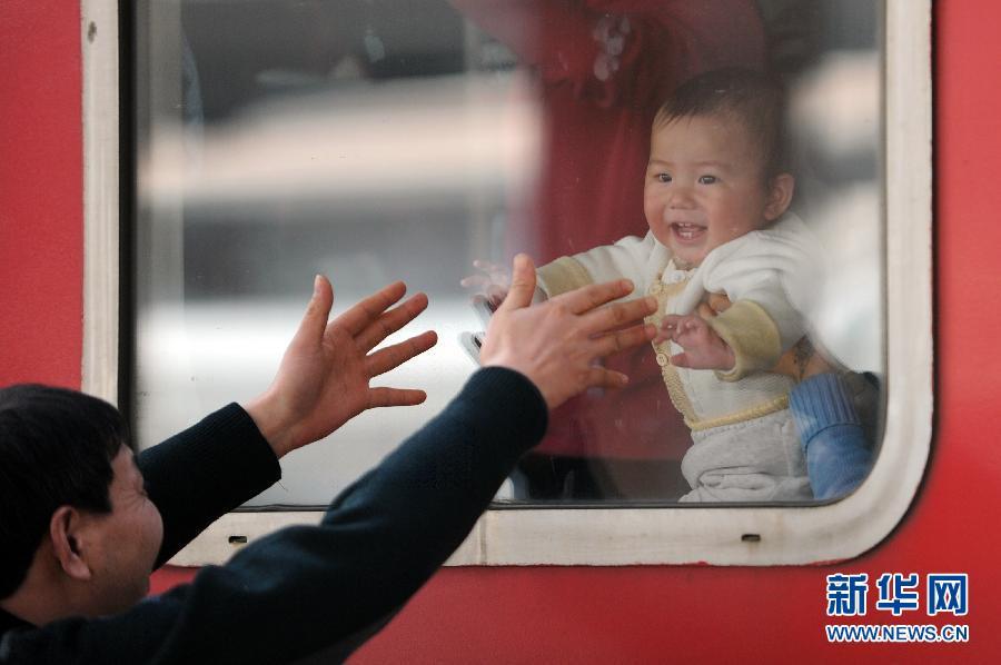 　在杭州火车站，在宁波东开往广州的列车停车间隙，阳先生在窗外与自己的小孙子透过车窗互动（2013年1月26日摄）。新华社记者 鞠焕宗 摄 图片来源：新华网