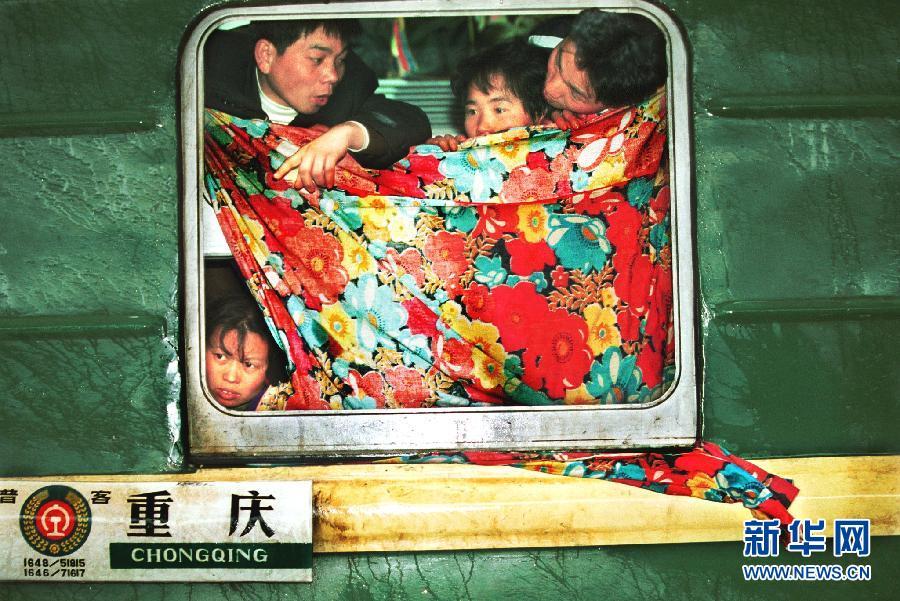 从厦门开往重庆的列车路过汉口火车站时，挡风被单里的民工（2001年1月21日摄）。 新华社发 图片来源：新华网