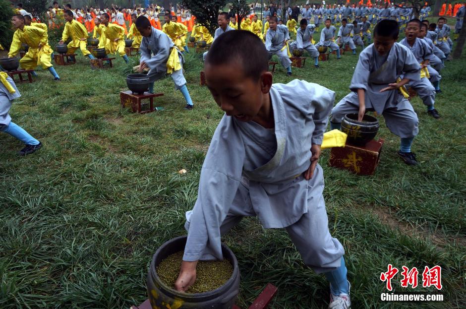 10月19日，塔溝武校的學(xué)子表演少林絕技。當(dāng)日，第十屆中國鄭州國際少林武術(shù)節(jié)開幕，塔溝武校6700名學(xué)員進行了少林棍、梅花樁、鐵砂掌、上罐功、倒吊功、飛檐走壁、沙袋功、鐵牛耕地等少林絕技展示，令現(xiàn)場中外嘉賓震撼不已。 中新社發(fā) 楊正華 攝