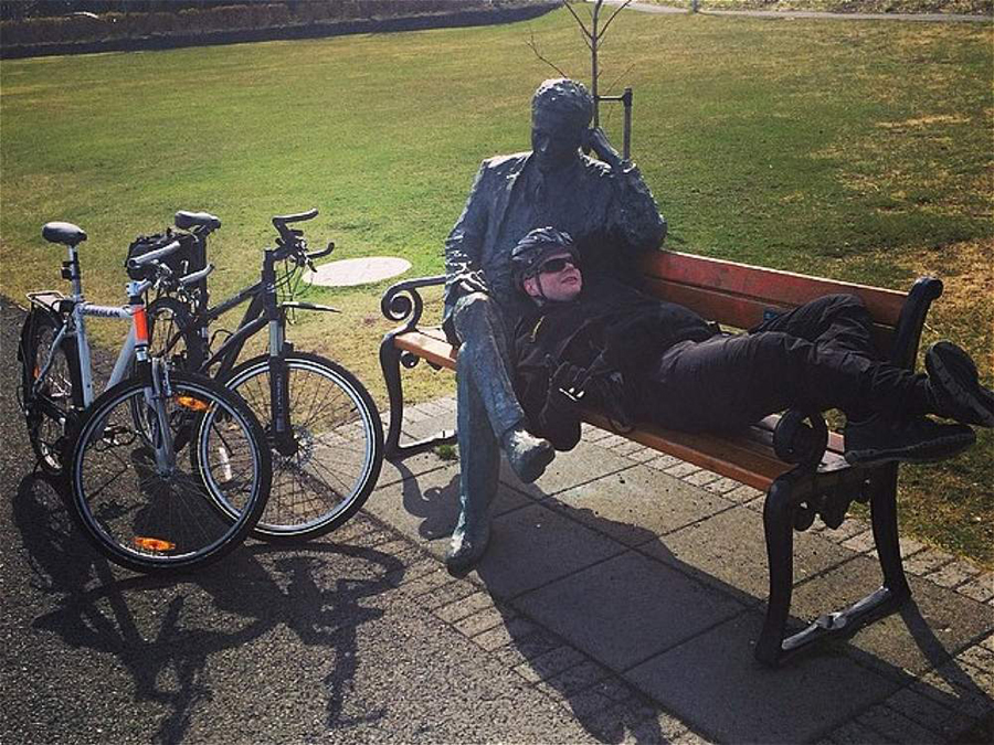 骑警躺在公园长椅上,枕着雕像的大腿,好自在!