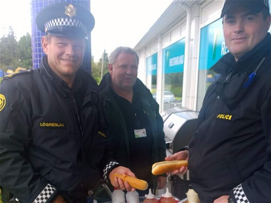 警察们在路边摊上吃热狗。