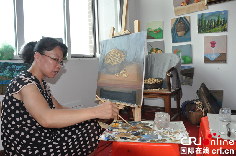 青岛平度市公益油画培训让文化扶贫见真章_fororder_7月14日，刘爱萍在智汇谷文化产业园画室内写生创作油画“平度大花生”_副本