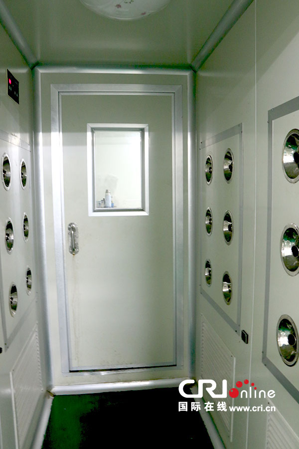 在真正进入包装车间前,工人们要通过这个通道。通道两侧有出风口,穿戴和消毒完毕的工人在此转身一周,以便吹走头发或其他碎屑。(摄影 刘澄圆)