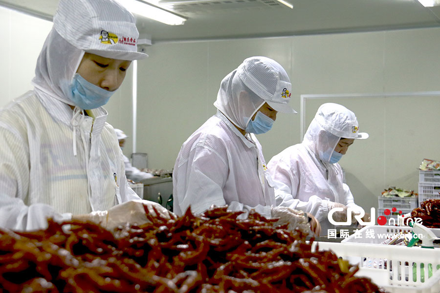 工人们戴着专用手套,将成品逐个装进包装袋内。(摄影 刘澄圆)