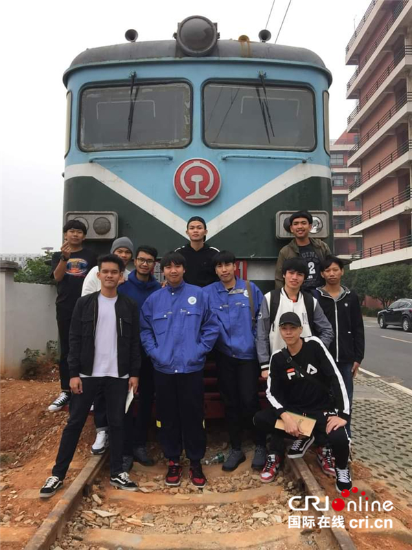 【坐高铁 看中国 老外说】泰国小伙儿郑齐光在中国学高铁检修 “等中泰铁路建好我就能走我梦想的路”_fororder_郑齐光（前排左一）与同学们在火车前合影（受访对象供图）._副本1