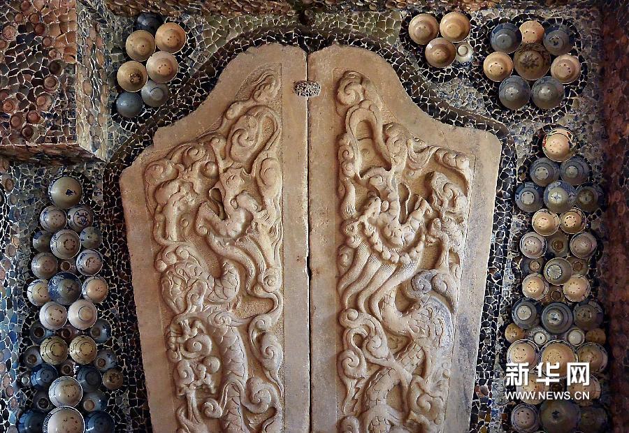 瓷房子内的一面墙体上,两件古代石刻精品与周围镶嵌的瓷碗、瓷片相得益彰(5月17日摄)。新华网图片 王颂 摄