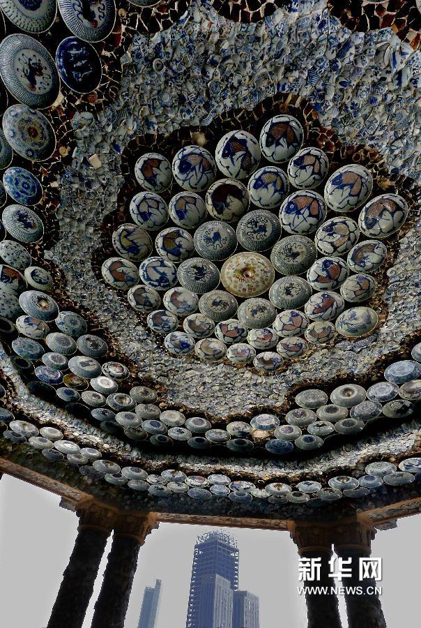 瓷房子内一处圆形露台顶墙上,镶嵌着大批不同朝代的瓷碗,与远处的正在建设中的楼厦成鲜明反差(5月17日摄)。新华网图片 王颂 摄
