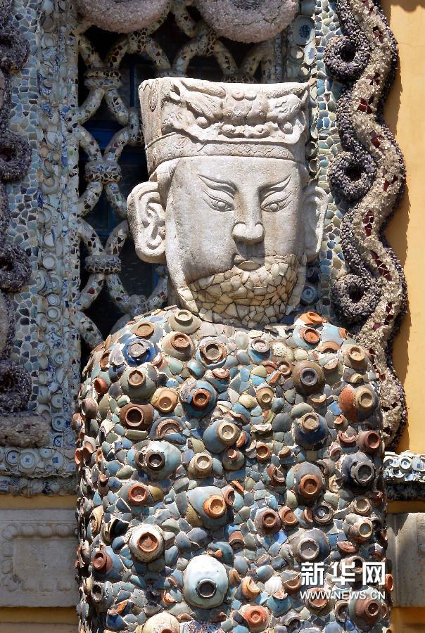 矗立在瓷房子外由一件受损的石雕头像和大量古瓷碗片镶嵌成的立体造像(5月17日摄)。新华网图片 王颂 摄