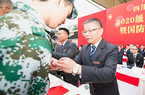 开学典礼金句频出 四川轻化工大学校长邀请新生“盘一盘”新校区_fororder_4学校党委书记王洪辉为新生代表佩戴校徽（摄影-廖志全）