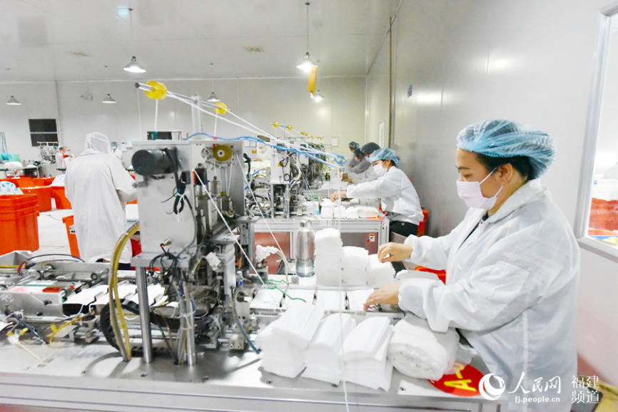 1月29日晚,漳浦县健德医疗器械有限公司厂房内工人加紧生产医用口罩