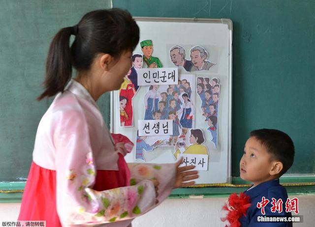 朝鮮學生手捧花束佩戴大紅花迎接新學期