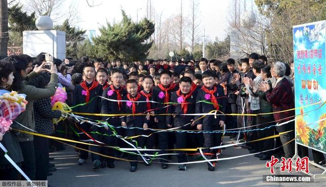 朝鮮學生手捧花束佩戴大紅花迎接新學期