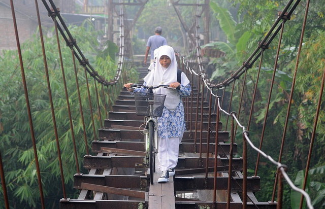 危险的求学路：印尼儿童30米高木吊桥上骑车上学