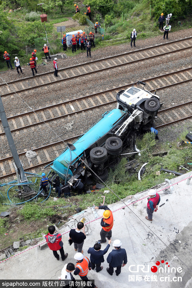 韩国釜山一油罐车横卧铁路 系与两汽车相撞后跌落