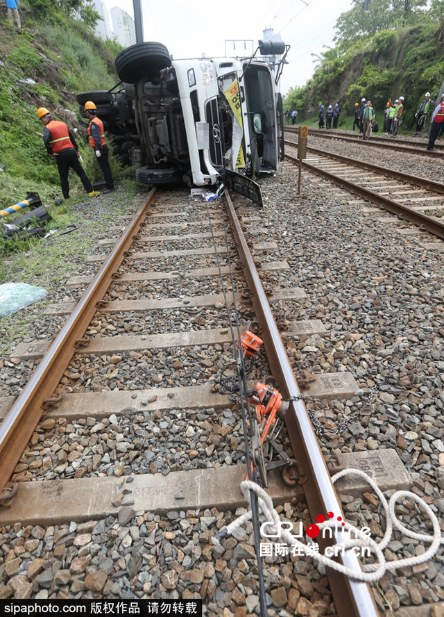 韩国釜山一油罐车横卧铁路 系与两汽车相撞后跌落
