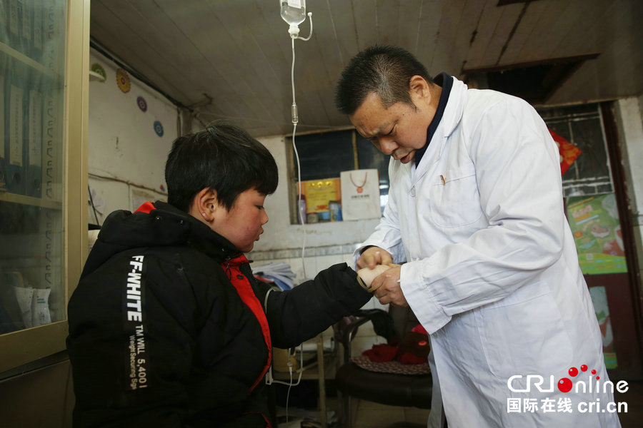村医王宗敏(右)在村卫生室为患者扎针输液