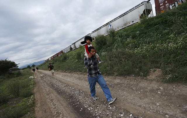 实拍美墨边境非法移民偷渡惊险场景:拖儿带女爬火车