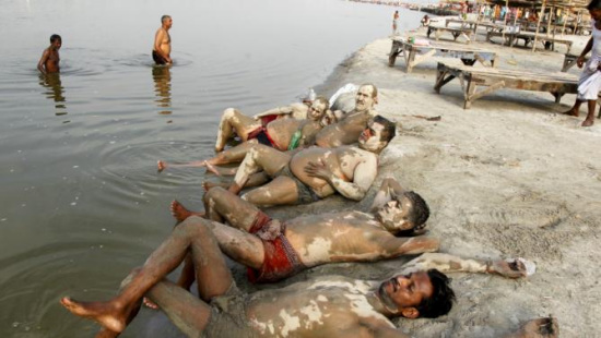 印度高温持续酷热难耐 民众恒河消暑涂泥巴降温