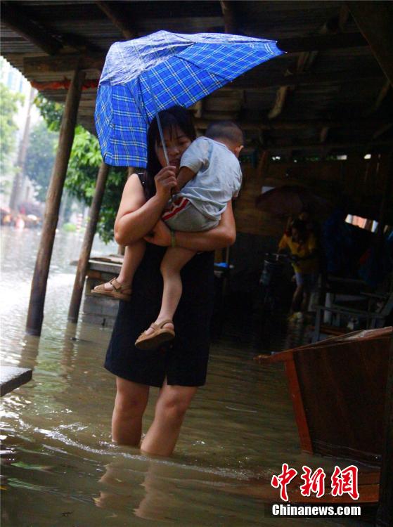 廣西暴雨致街道積水過膝 民眾涉水送子上學