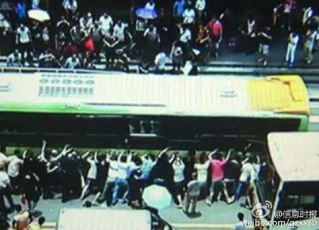 广州76岁老妇被公交车卷入车底 近百人抬车解救