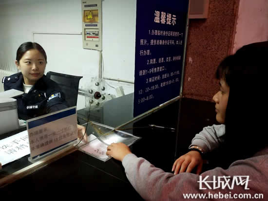 女民警易楠在售票廳制證窗口為旅客辦理臨時身份證.王馨圖