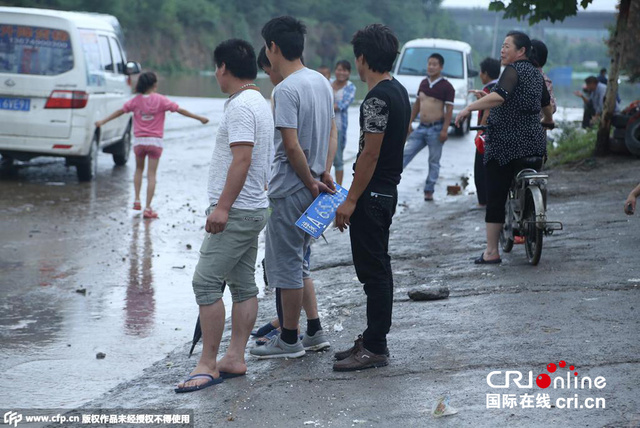 郑州被淹 村民积水里捞车牌卖钱一个100元