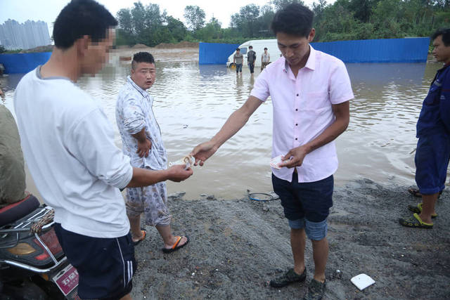 郑州被淹 村民积水里捞车牌卖钱一个100元