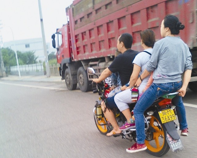 四川“瘋狂”摩托車 一車載6人超越運渣車