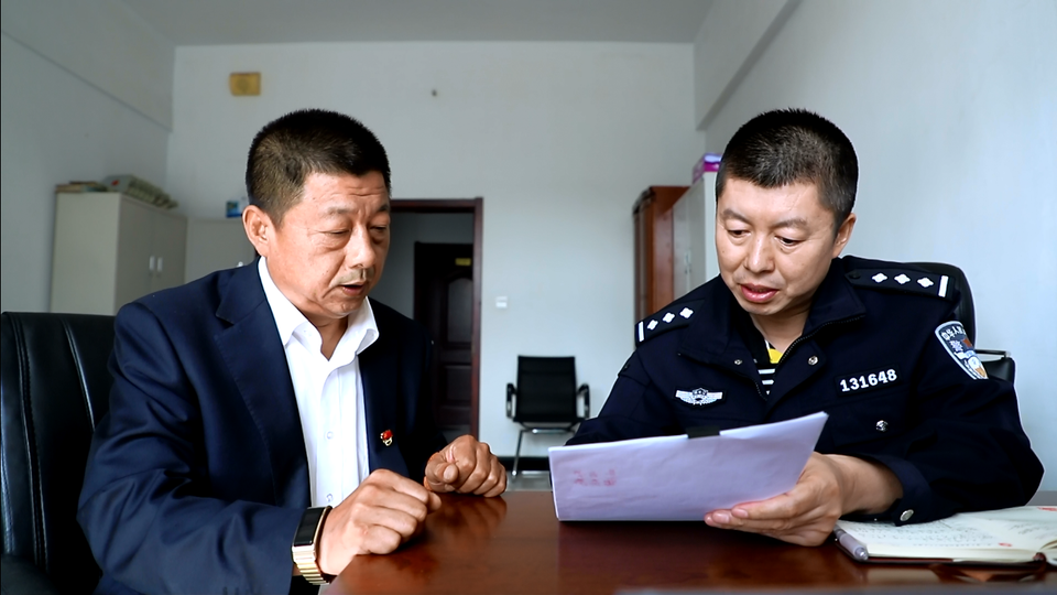 6969冯江(左)配合北安市公安局经侦大队公安干警整理资料 供图