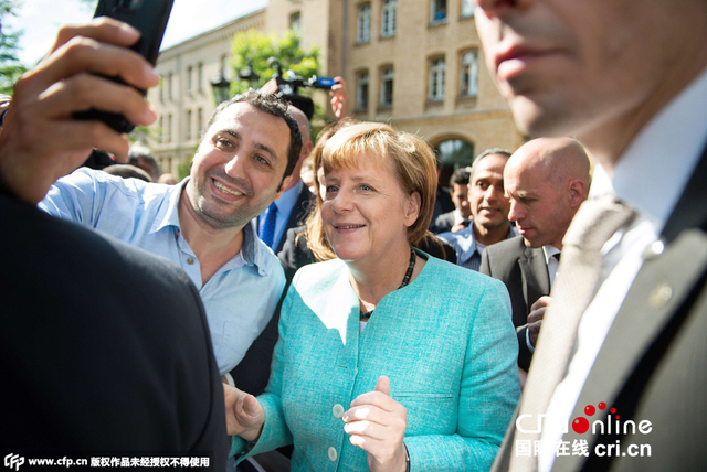 德国总理默克尔慰问抵德难民 玩自拍秀亲民