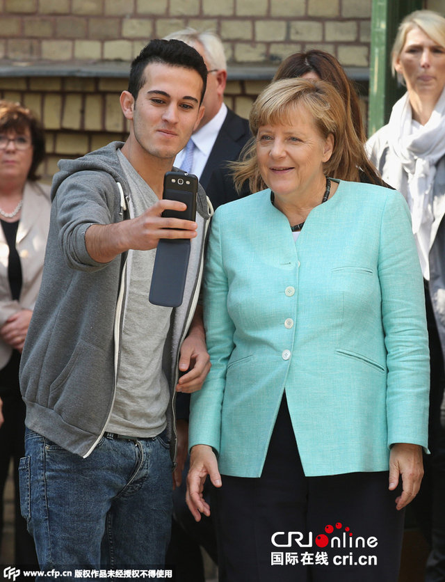 德国总理默克尔慰问抵德难民 玩自拍秀亲民