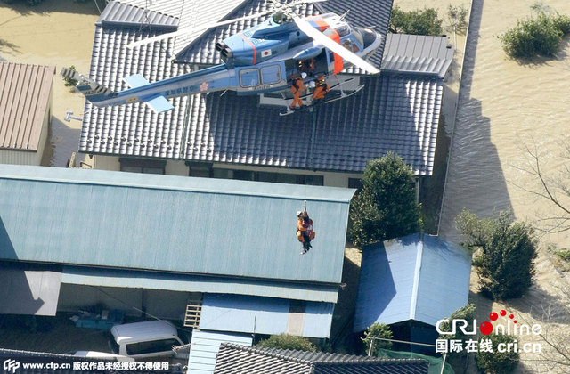 日本暴雨致上万房屋被淹 居民抱狗爬屋顶等救援