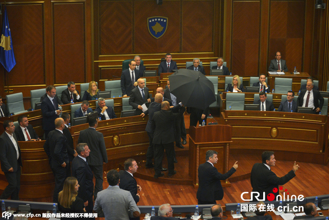 科索沃反对党议员向总理“扔鸡蛋” 安保人员打伞护卫