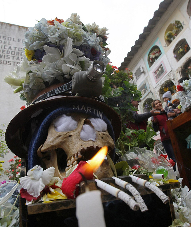 玻利维亚人装扮死人头骨祈福 为其戴帽子鲜花
