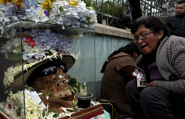 玻利维亚人装扮死人头骨祈福 为其戴帽子鲜花