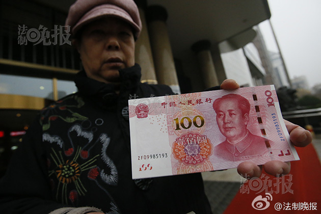 新版土豪金百元大钞拿到手市民围观拍照