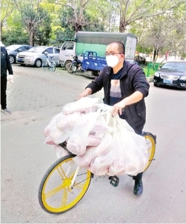 物業小哥騎單車給居民運套餐 100多斤豬肉挂滿車把