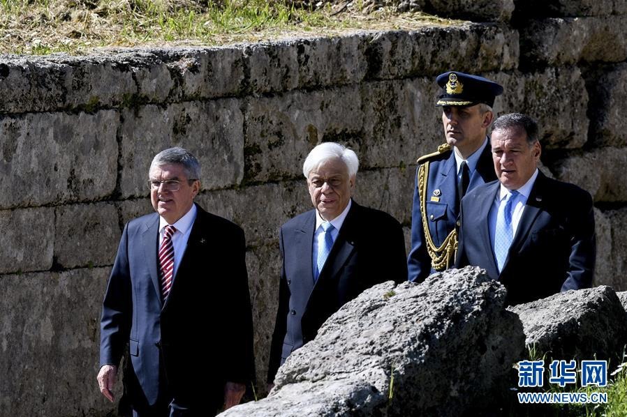 3月12日，国际奥委会主席巴赫（左一）、希腊总统帕夫洛普洛斯（左二）、希腊奥委会主席卡普拉洛斯（右一）走进圣火采集仪式现场。 当日，2020东京奥运会圣火采集仪式在希腊古奥林匹亚举行。 新华社发（安东尼斯·尼科洛普洛斯摄）