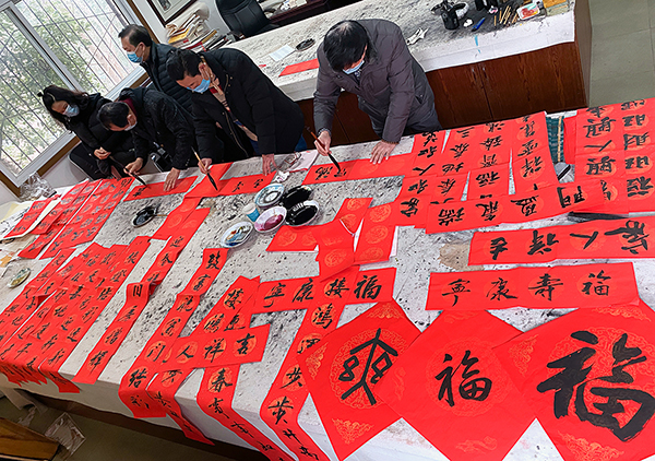 立春日 四川内江百步“云梯”送福来_fororder_4书写春联（摄影-王斌）