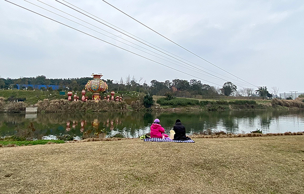 绿地青青莫踩踏 向不文明行为说“不”_fororder_市民在绿地上席地而坐（摄影-杨梦婧）