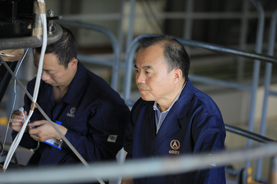 刘志让(右二)现场察看发动机试车传感器装置实施动力重