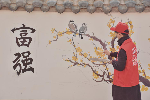 重庆北碚：西南大学大学生“学雷锋”义务画墙绘 装点美丽乡村