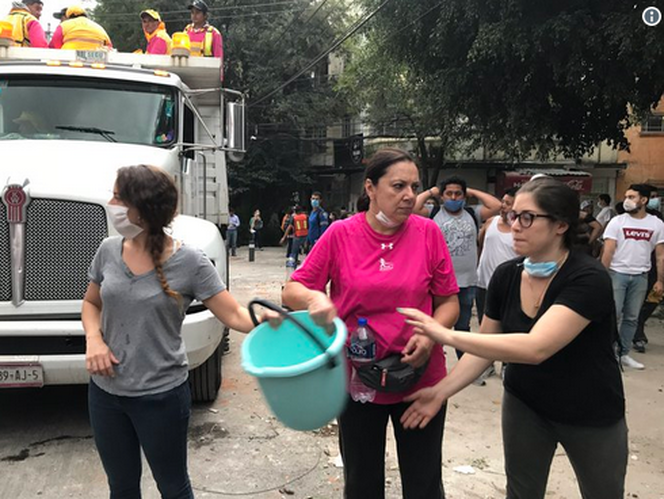 在Condesa附近的墨西哥人帶著水桶和排成一行的隊伍從嚴重受損的建築中帶走了瓦礫_fororder_{13B5F782-8503-4CCD-B0C4-7B356FF135DD}