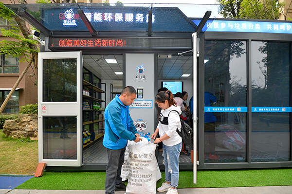 倡导垃圾分类新概念 自贡市首个智能环保服务站正式启用_fororder_3居民黄敏（右）兑换废旧物品（摄影-廖志全）